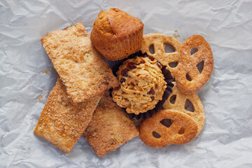 Various cookies for lunch. The heap of  sweets on crumpled paper background, view from above.