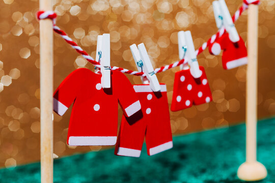 Miniature Santa Claus costume on clothesline with festive Christmas decor