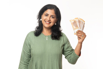 Smiling Attractive Beautiful Indian Woman showing Indian rupees and confident expressions. standing...