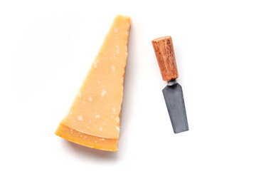 Parmesan cheese wedge with a knife, overhead flat lay shot, isolated on a white background