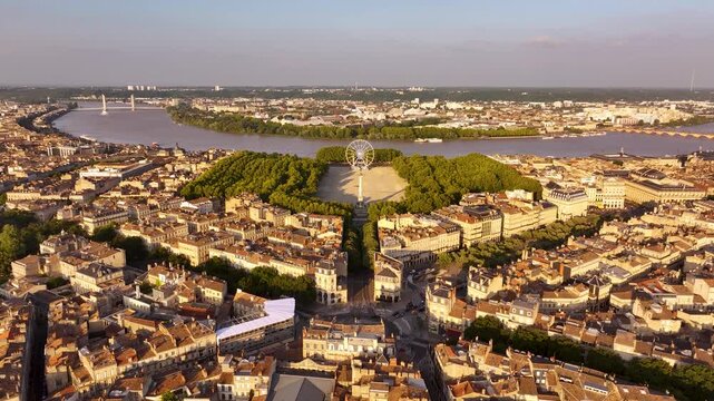 Aerial view of the Place des Quinconces, a vast esplanade with contrasting golden buildings and lush green trees, Bordeaux, Nouvelle-Aquitaine, France.