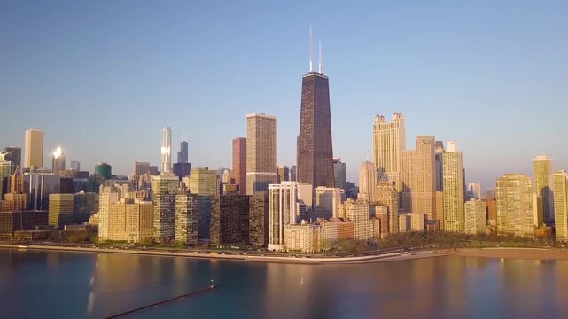Aerial view of Chicago's impressive skyline, featuring the iconic John Hancock Center, reflected in the serene waters of Lake Michigan, Chicago, Illinois, United States.