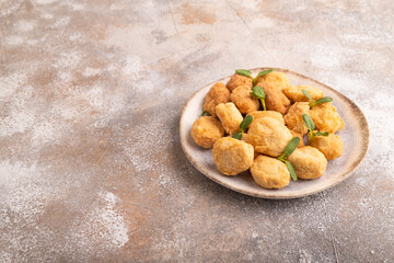 Fried crispy Chicken Nuggets with ketchup, microgreen on brown concrete. side view, copy space