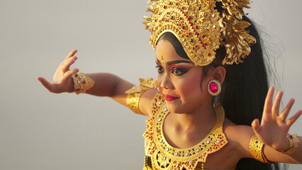A young indonesian girl dancer performing balinese traditional dance wearing costume and makeup, culture, tradition, legong