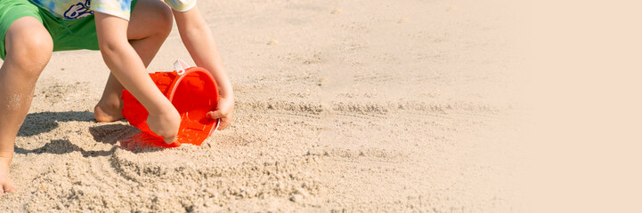 Child Playing with Sand and Bucket on Beach