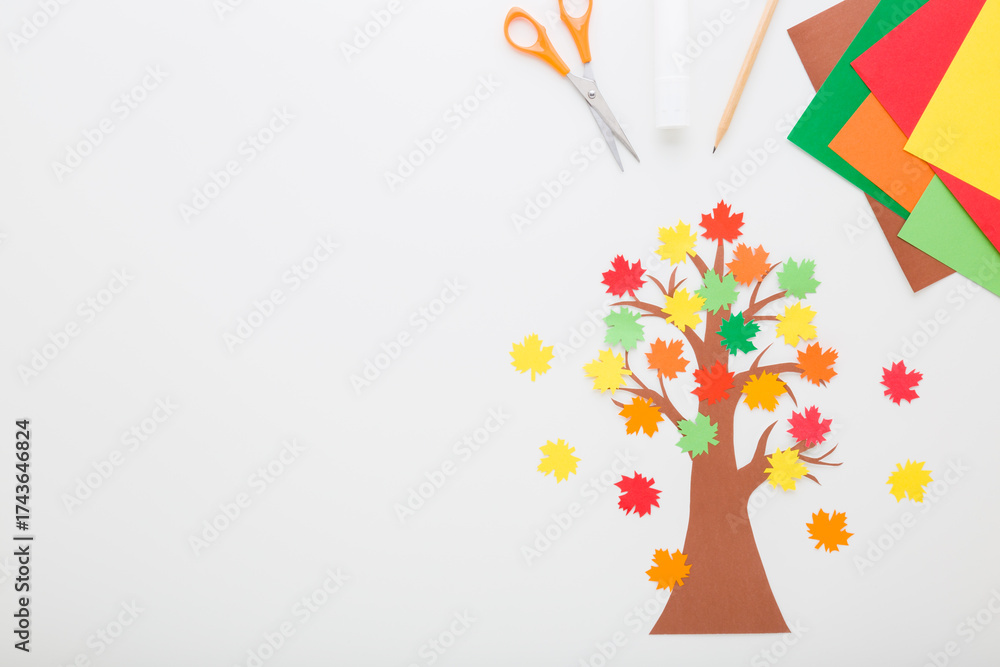Wall mural created tree with colorful maple leaves from application paper, glue stick, scissors on light gray t
