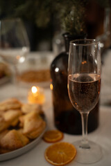 Restaurant concept. New Year and Christmas festive table. Festive tree in a vase on the table. Dishes and glasses are beautifully served on celebration. Aesthetic vertical photo.
