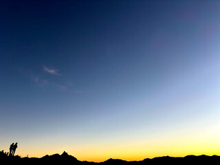 夜明け前のグラデーションが広がる山の稜線と静寂な空の風景