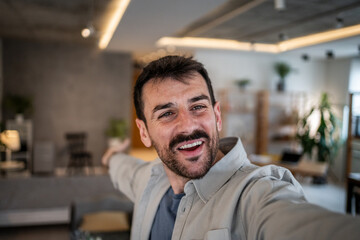 Obraz premium Smiling man making a video call during an online meeting