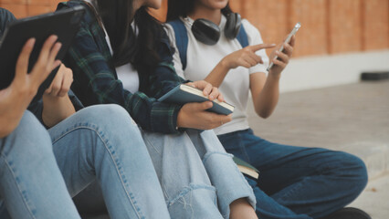 Happy students walking together on university campus, chatting and laughing outdoors after classes