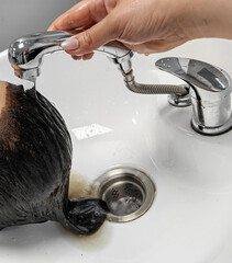 Removing hair dye after coloring in a modern salon sink. Concept for hair care treatments in the salon or at home.