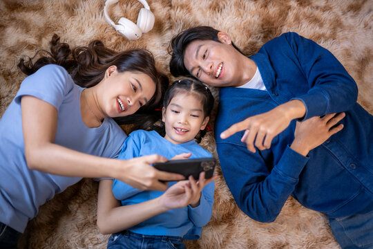 Asian family enjoying digital entertainment together at home