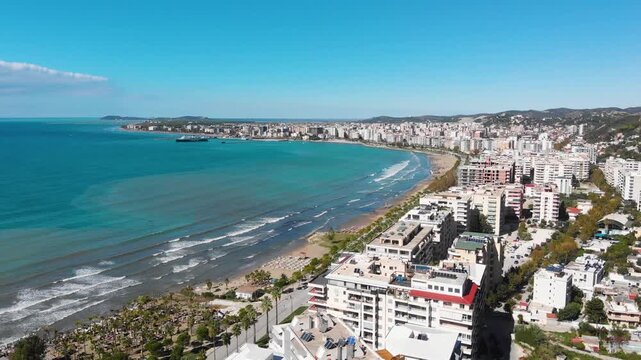Aerial drone view of the stunning Albanian Riviera coastline, near the city of Vlora, Saranda showcasing pristine white beaches, turquoise sea water, cliffs and mountains under the Mediterranean sun.
