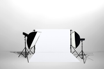 Minimalist studio lighting setup with softbox lights, stands, and a white backdrop. Copy space. Product shooting, e-commerce, portrait, and general studio. Professional setup for showcasing products © Leo Lintang
