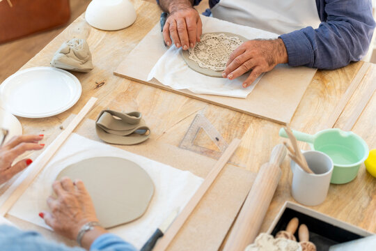 People taking ceramics workshop making handmade pottery - Powered by Adobe