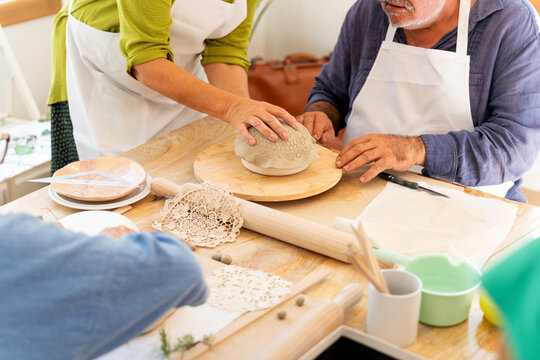 Seniors learning ceramics during pottery workshop - Powered by Adobe
