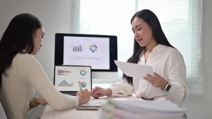 Businesswomen discussing financial charts and documents - Powered by Adobe