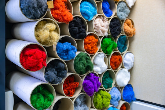 Morceaux de laine de diff&eacute;rentes couleurs formant une composition textile vibrante et riche en textures.