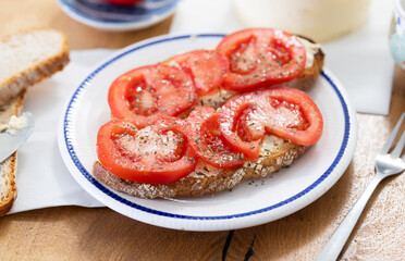 two bruschettas with tomato slices on a plate