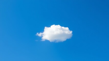 Single fluffy cloud in a vast blue sky, serene atmosphere.