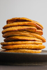 A close-up stock photo of a stack of fluffy pumpkin spice pancakes topped with syrup