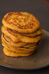 A close-up stock photo of a stack of fluffy pumpkin spice pancakes topped with syrup