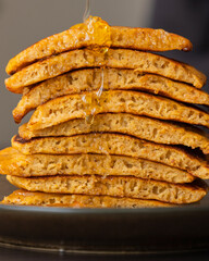 stack of pumpkin spice pancakes with a slice showing the fluffy texture