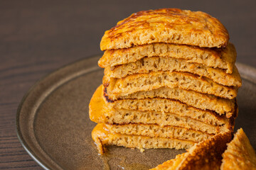 stack of pumpkin spice pancakes with a slice showing the fluffy texture