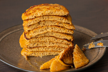 stack of pumpkin spice pancakes with a slice showing the fluffy texture
