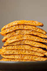 stack of pumpkin spice pancakes with a slice showing the fluffy texture