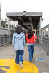 Two teens walking on a yellow line