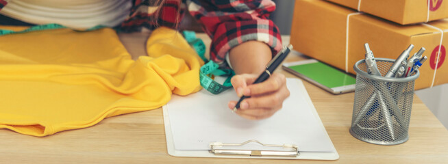 Banner Asian woman startup small business home office. Banner Online seller young asian woman use digital tablet checking online order stock. Woman using tablet check stock shipping with copy space