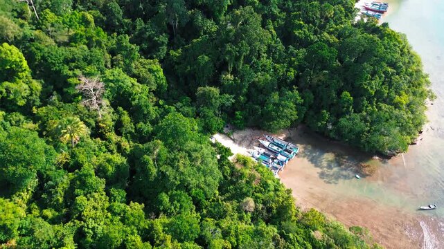 Wide aerial panorama of the tranquil lagoon surrounded by hills at Sendang Biru and Pulau Sempu.