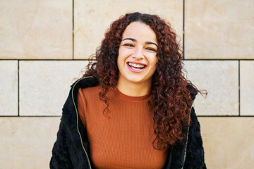 Happy young woman laughing with curly hair
