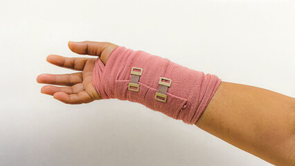 Close-up of a hand wrapped in an elastic compression bandage for a sprain or injury, isolated on a...