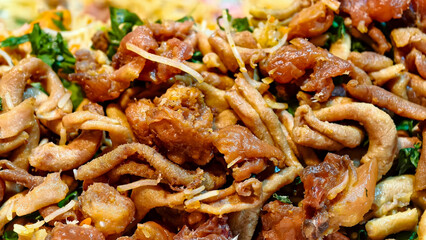 Close-up shot of a delicious and savory dish, fried intestines with various kinds of meat and vegetables.