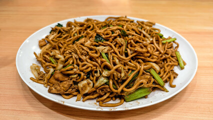 A delicious plate of traditional Javanese fried noodles with chicken and mixed vegetables, a classic Asian culinary experience served fresh and flavorful.