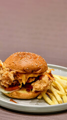 Golden fried chicken burger with sesame bun paired with a side of crispy fries delight