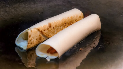 Two rolled kebabs are being prepared, ready to tempt your taste buds with each deliciousness