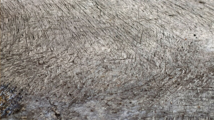 Close-up view of a textured, weathered surface with numerous scratches and lines.