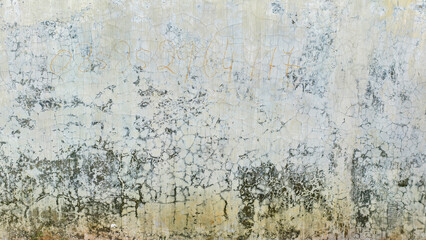 Weathered and aged plaster wall with intricate patterns of cracks 