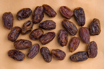 Dates fruit on brown paper background. Top view. Copy space.