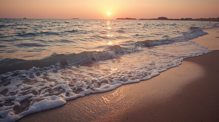 Sunset over ocean waves on sandy beach
