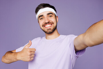 Young strong fitness trainer instructor sporty man sportsman wear headband t-shirt train in home...