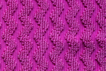 Intriguing texture in vibrant pink fabric showcasing zigzag patterns in soft, fluffy fibers on a cozy afternoon