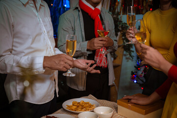 Happy friends celebrating Christmas at home Friends gather at home for a traditional Christmas dinner, young couples enjoying the festive food.