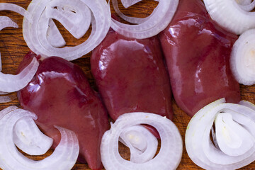 Slicing fresh onions and preparing chicken livers in a cozy kitchen on a sunny afternoon