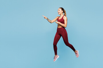 Full body young fitness trainer instructor woman sportsman wears red sportswear train in home gym...