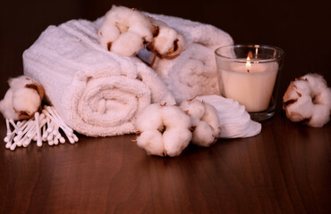 Cotton plant, swabs and white towels on a wooden background stock photo images. Spa still life with towels, scented candle and cotton flowers on wooden background. Template for background, banner