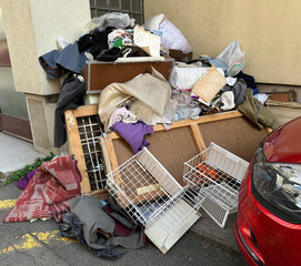 Garbages on the street next to a building